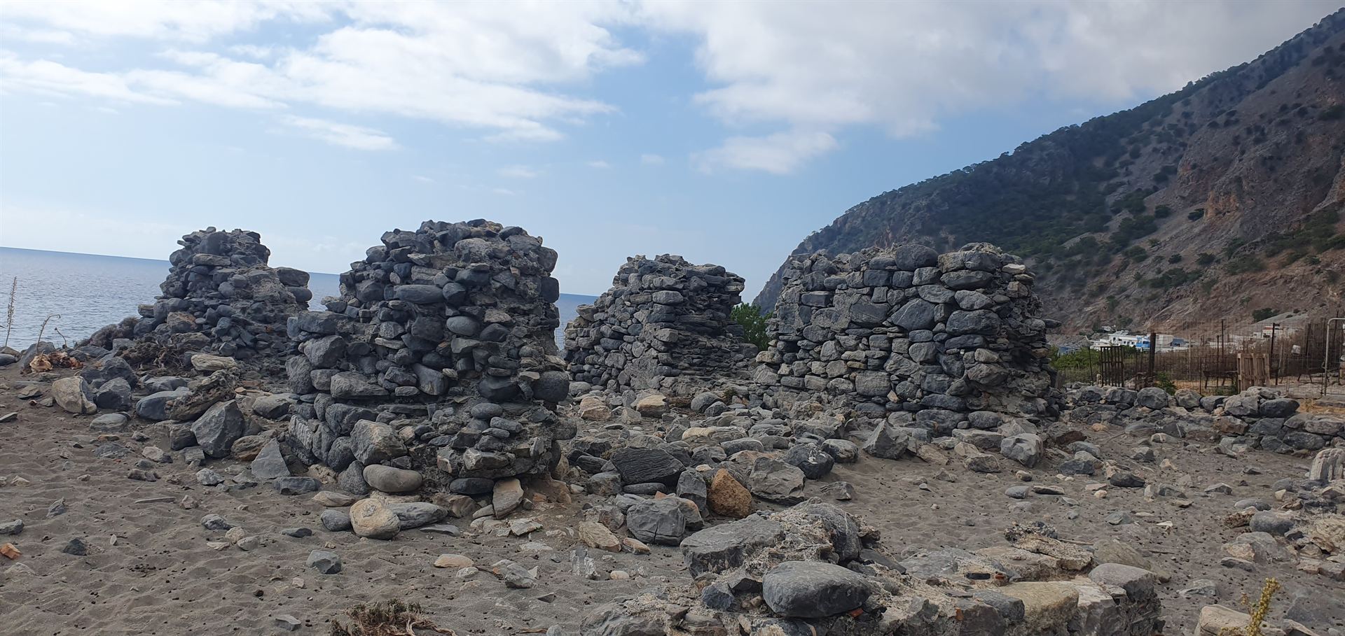 Old stone ruins on the black-pebble beach at Agia Roumeli